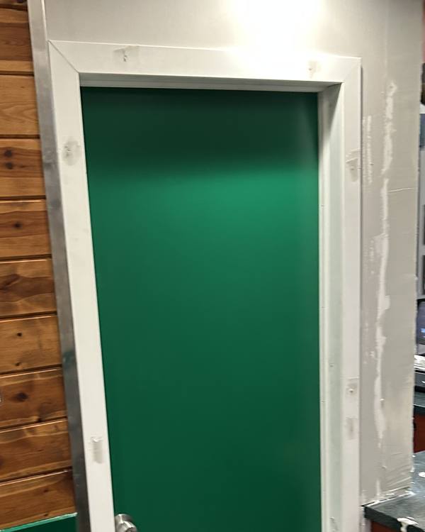 New door frame and wall patched with joint compound, before painting