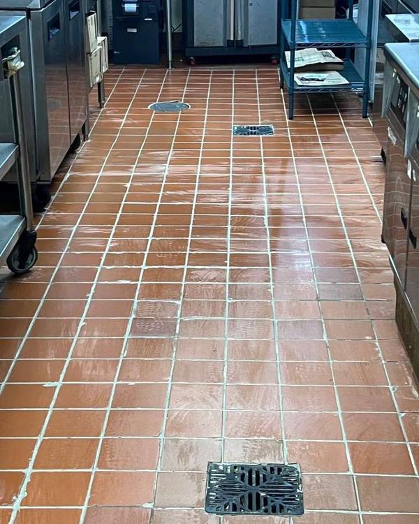 Commercial kitchen tile floor being cleaned