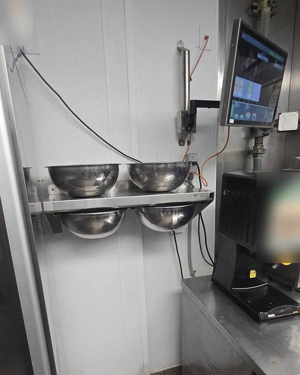 Wall-mounted kitchen TV screen and stainless steel shelf installed