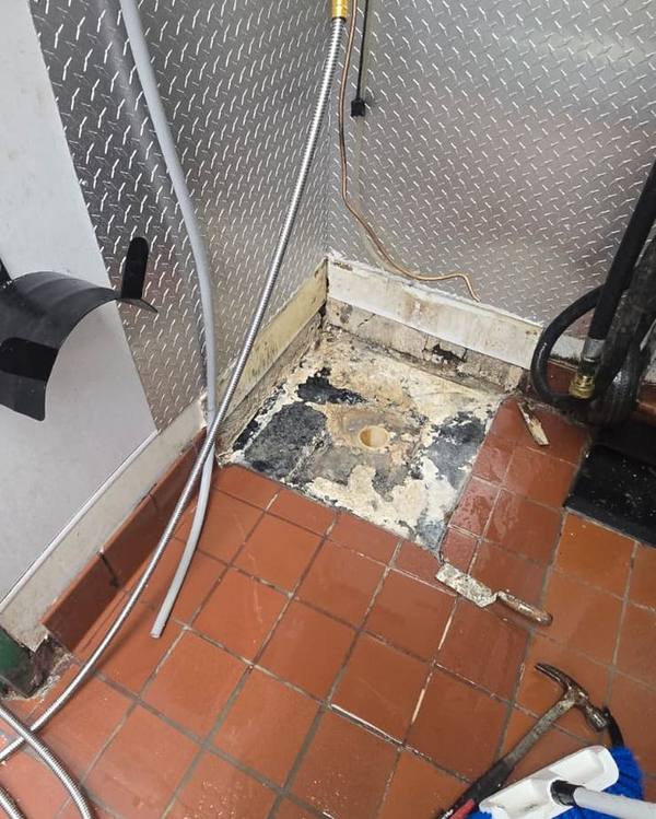 Old mop sink removed, exposing a damaged floor base