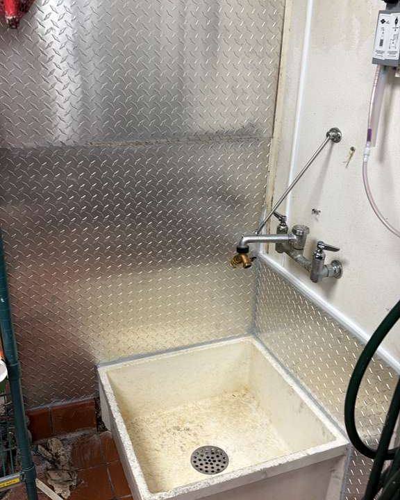Renovated commercial mop sink with new metal wall panels
