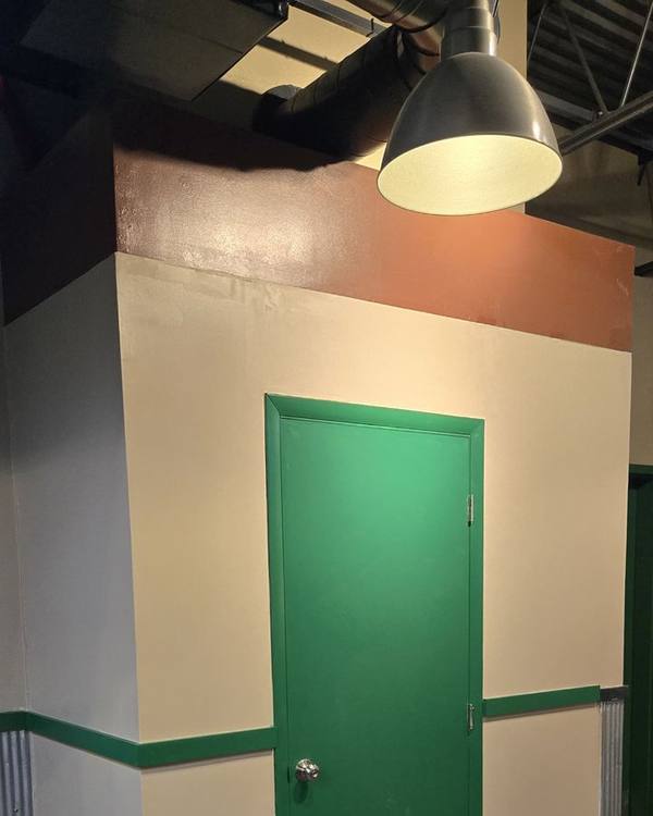 Newly built drywall enclosure, painted, with a green door and trim